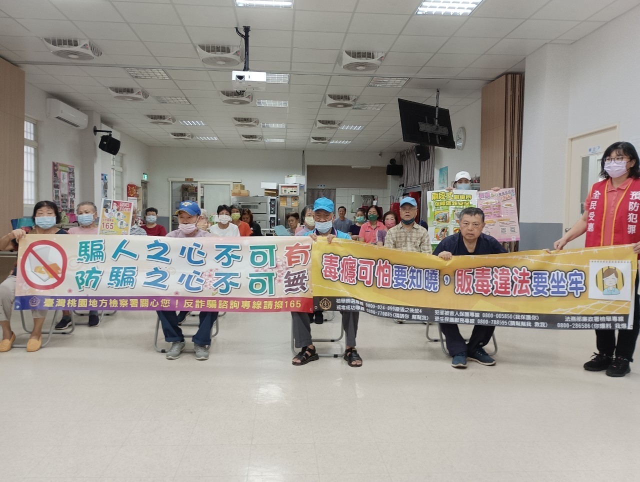 與銀髮族長者手持標語展現社區堅決抵制毒品和詐騙行為之決心