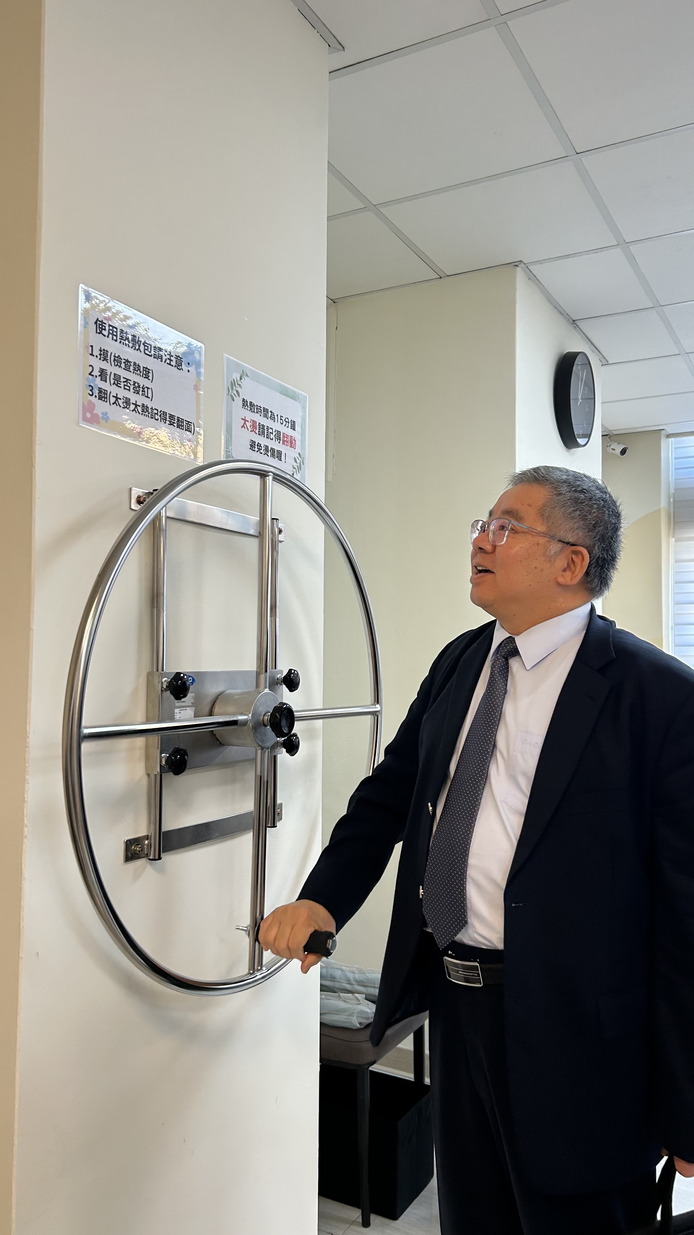 圖八、戴文亮檢察長實地親測手臂復健肌力器