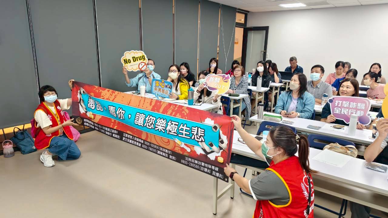 本署同仁和工商企業員工一起高舉反毒打詐活動標語及布條